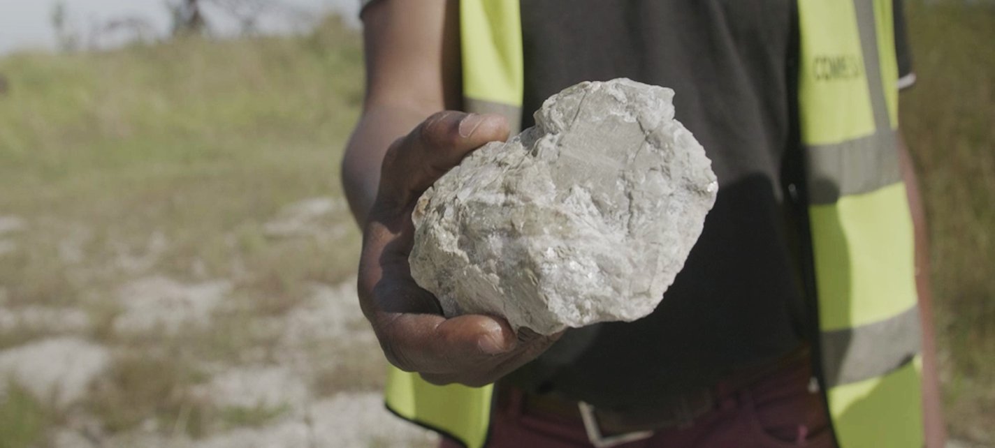 A worker holds a lump of lithium ore in Manono DRC 2023
