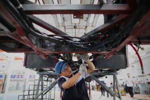 A Chinese worker assembles a hybrid NEG bus.jpg