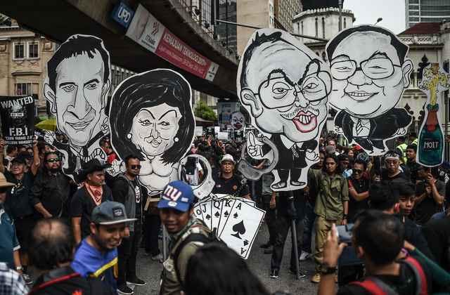 Student activists holds up clown-faced caricature of Malaysian Prime Minister Najib Razak (2nd R) and his wife Rosmah Mansor (2nd L) during a protest over a financial scandal involving state fund, 1MDB, in Kuala Lumpur on August 27, 2016.