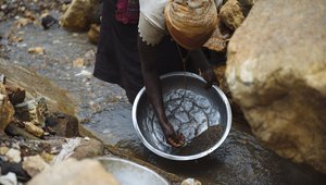 Woman panning for cassiterite DRC
