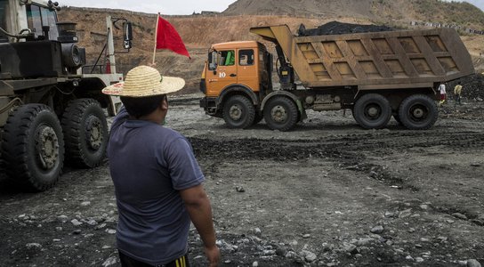 Minzayar Myanmar mining - man with red flag in front of dump truck
