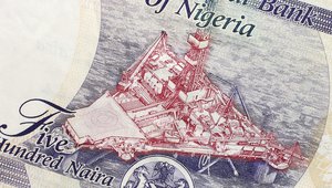 Part of Nigerian currency with oil platform
